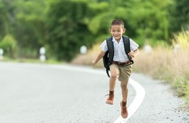 Child with backpack running happily