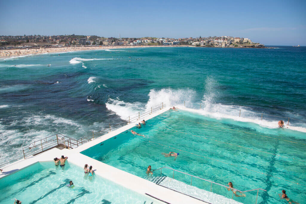 Bondi beach, Sydney, NSW, Australia - November 1, 2015: People swimming in the fresh water swimming pools built in to the sea with waves rolling in to Bondi and breaking against the edge of the pool